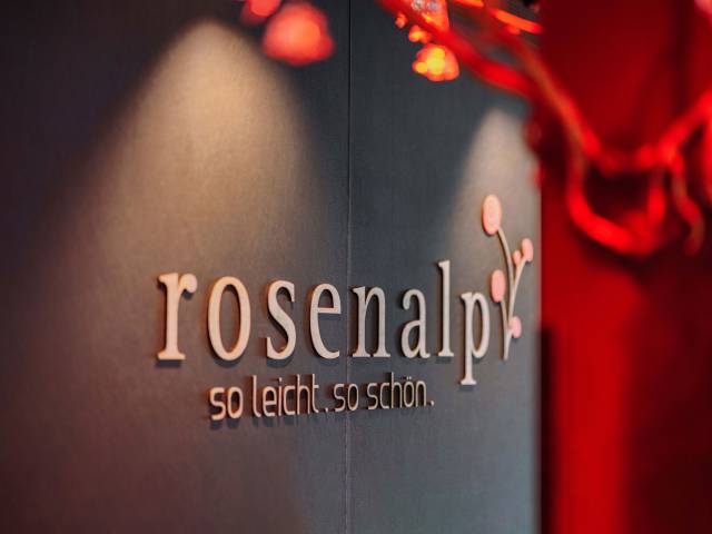 Ein Wanddekor mit dem Logo und Slogan des Rosenalp Gesundheitsresort & Spa.